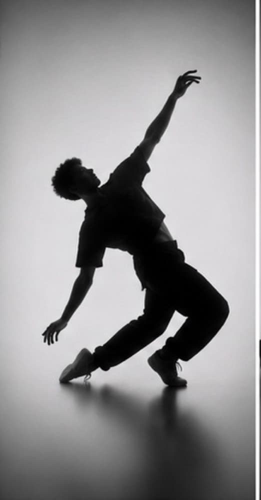 Silhouette of a male dancer in motion, one arm raised