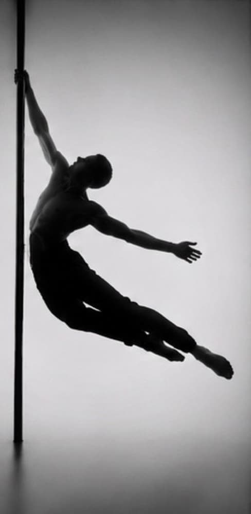 Silhouette of a male dancer suspended on the pole, his body arched